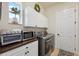 Well-equipped laundry room with white cabinets, stainless steel washer/dryer, and countertop appliances at 9426 Burnam Dr, Weeki Wachee, FL 34613