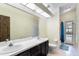 Bathroom with double sinks, a large mirror, toilet, and a shower with glass doors leading to the pool area at 9774 Bohart Ct, Orlando, FL 32836