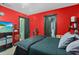 Bedroom with red accent wall, TV and decorative shelving unit at 9774 Bohart Ct, Orlando, FL 32836