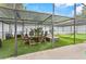 Covered patio with an outdoor dining set, lounge chair, and hammock at 9774 Bohart Ct, Orlando, FL 32836