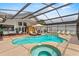 Resort-style pool with covered enclosure, hot tub, and outdoor seating areas at 9774 Bohart Ct, Orlando, FL 32836