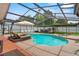 Sparkling pool area with covered enclosure, lounge chairs, and outdoor dining at 9774 Bohart Ct, Orlando, FL 32836