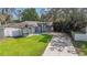 Charming single-story home featuring a well-manicured lawn, concrete driveway, and lush landscaping at 1008 Jackson Creek Ct, Oviedo, FL 32765