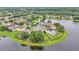 An aerial view showing lush landscaping, a pond, and well-maintained houses in a suburban community at 10836 Tilston Pt, Orlando, FL 32832