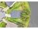 Aerial view of a dark roof home with a lake view and landscaping in a residential neighborhood at 10836 Tilston Pt, Orlando, FL 32832