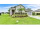 Home exterior with palm tree, manicured landscaping, covered entryway and two car garage at 10836 Tilston Pt, Orlando, FL 32832
