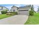 Close up of the home's exterior showing the two-car garage, driveway and manicured landscaping at 10836 Tilston Pt, Orlando, FL 32832