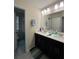 Bathroom featuring double sinks, dark wood cabinets, and large mirror at 11097 N Folklore St, Winter Garden, FL 34787
