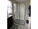 Bright bathroom featuring a glass-enclosed shower with silver trim and large square gray flooring at 11097 N Folklore St, Winter Garden, FL 34787