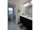 Bathroom featuring double sinks, dark wood cabinets, and large mirror with connected full bath at 11097 N Folklore St, Winter Garden, FL 34787