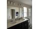 Bathroom with a vanity, double sinks, and large mirror. Shower with a sliding door is shown in reflection at 11097 N Folklore St, Winter Garden, FL 34787