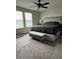 Bedroom with carpet flooring, ceiling fan and bench seating at the end of the bed. Two windows for natural light at 11097 N Folklore St, Winter Garden, FL 34787