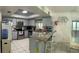 Well-lit kitchen offers modern appliances, granite countertops, and white tile flooring at 114 Madeira Ave, Orlando, FL 32825