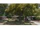 Modest house exterior with a car parked on the driveway and large trees at 134 Flamingo Dr, Auburndale, FL 33823