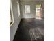 Empty room with damaged walls and floors, featuring an open doorway and natural light at 134 Flamingo Dr, Auburndale, FL 33823