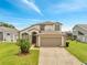 Charming two-story home featuring an attached two-car garage and well-manicured lawn and landscaped yard at 13404 Bradwater Ct, Orlando, FL 32828