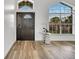 Foyer featuring hard-surface flooring, front door, modern decor, and a large window providing natural light at 13404 Bradwater Ct, Orlando, FL 32828