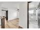 Hallway with hardwood floors leading to an open room with ceiling fan and a bathroom at 13404 Bradwater Ct, Orlando, FL 32828