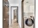 Bright laundry room features white cabinetry, tile backsplash, and modern, stainless-steel, front loading washer and dryer at 13404 Bradwater Ct, Orlando, FL 32828