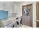 Convenient laundry room with white cabinets, subway tile, and modern Samsung front loading washer and dryer at 13404 Bradwater Ct, Orlando, FL 32828