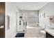 Bright bathroom showcases walk-in shower, soaking tub beneath arched window, and modern white tile at 13404 Bradwater Ct, Orlando, FL 32828