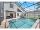 Beautiful in-ground pool with a screened enclosure, surrounded by lush landscaping and seating at 13404 Bradwater Ct, Orlando, FL 32828