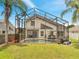 A backyard featuring a screened-in pool, with outdoor seating and meticulously landscaped yard with shade at 13404 Bradwater Ct, Orlando, FL 32828