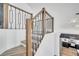 A staircase with wood and metal railings leads to the upper level, with partial kitchen view at 13404 Bradwater Ct, Orlando, FL 32828
