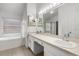 Large primary bathroom with double sinks, soaking tub, walk-in shower, and vanity with storage at 142 Stonegate Pass, Davenport, FL 33897
