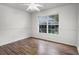 Well-lit bedroom with wood floors, a ceiling fan, and a large window at 142 Stonegate Pass, Davenport, FL 33897