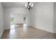 An empty dining room features neutral tiling and a modern chandelier at 142 Stonegate Pass, Davenport, FL 33897