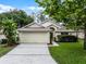 Well-maintained single-story home with a two-car garage, landscaping, and a lush green lawn at 142 Stonegate Pass, Davenport, FL 33897