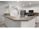 Open kitchen with stainless steel appliances, white cabinetry, and a peninsula island at 142 Stonegate Pass, Davenport, FL 33897
