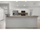 Spacious kitchen featuring white cabinets, stainless steel appliances, and a breakfast bar at 142 Stonegate Pass, Davenport, FL 33897