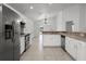 Bright kitchen with stainless steel appliances and a view of the living area at 142 Stonegate Pass, Davenport, FL 33897