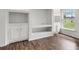 A spacious living room has wood flooring and a built-in shelving and storage unit at 142 Stonegate Pass, Davenport, FL 33897