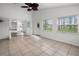An airy sun room features tile floors, a ceiling fan, and multiple windows for ample natural light at 142 Stonegate Pass, Davenport, FL 33897