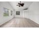 A bright sun room features tile floors, a ceiling fan, and multiple windows for ample natural light at 142 Stonegate Pass, Davenport, FL 33897