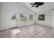 Bright sunroom features neutral tile flooring, three large windows, and a ceiling fan for added comfort at 142 Stonegate Pass, Davenport, FL 33897