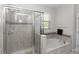 Bathroom with a glass door shower, a soaking tub, and tiled surround at 1431 Leitrim Loop, Apopka, FL 32703
