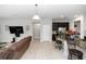 Open concept living room features tile floors, a TV, and flows into the kitchen area at 1431 Leitrim Loop, Apopka, FL 32703