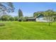 Expansive, well-maintained back yard with lush green grass, trees, and a screened in patio at 1507 Golfside Dr, Winter Park, FL 32792
