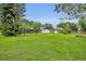 Expansive green back yard with mature trees, lawn, and an enclosed patio area at 1507 Golfside Dr, Winter Park, FL 32792