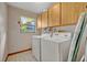 Functional laundry room with a modern washer and dryer, complemented by overhead cabinets for storage at 1507 Golfside Dr, Winter Park, FL 32792