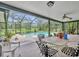 Inviting screened-in patio with a lovely table set overlooking the sparkling swimming pool and lush greenery at 1507 Golfside Dr, Winter Park, FL 32792