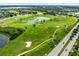 Scenic aerial of nearby golf course and ponds, with palm trees lining a nearby road at 15324 Black Lion Way, Winter Garden, FL 34787