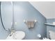 Cozy bathroom features blue walls, a pedestal sink and a round mirror at 15324 Black Lion Way, Winter Garden, FL 34787