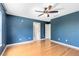 Blue bedroom features wood floors and a ceiling fan at 15324 Black Lion Way, Winter Garden, FL 34787