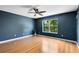Bedroom with blue walls, hardwood floors, a ceiling fan, and a window with green views at 15324 Black Lion Way, Winter Garden, FL 34787