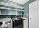 Laundry room with modern washer and dryer, shelving, and countertop space at 15324 Black Lion Way, Winter Garden, FL 34787